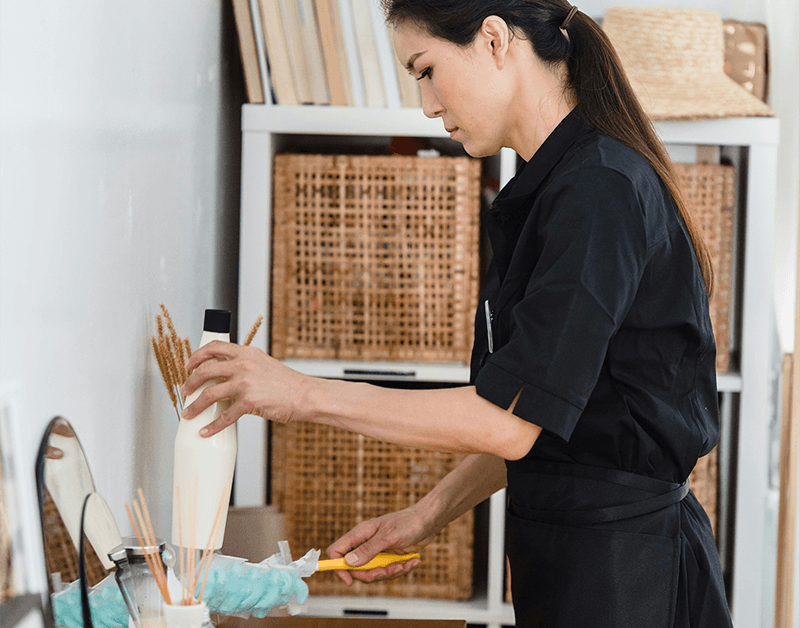 Domestic Helper Attentively Organising Housekeeping and Cleaning Supplies