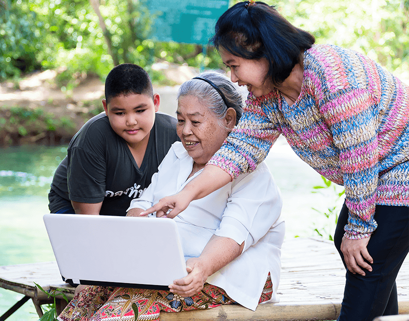 Family Members assisting Senior Citizen with Laptop Computer Content